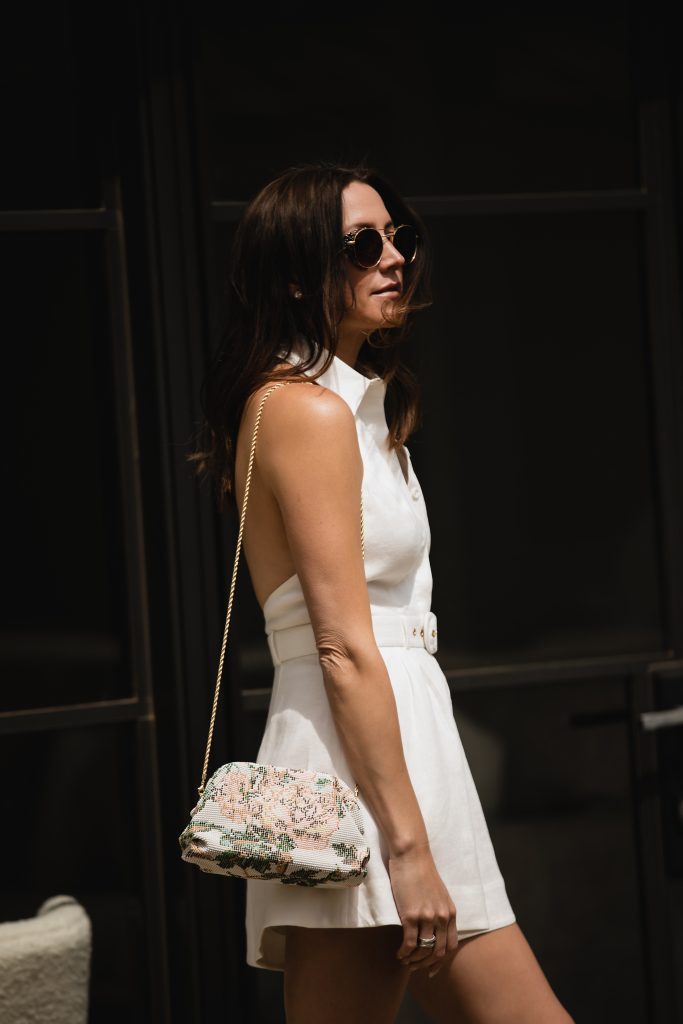 white romper and floral bag